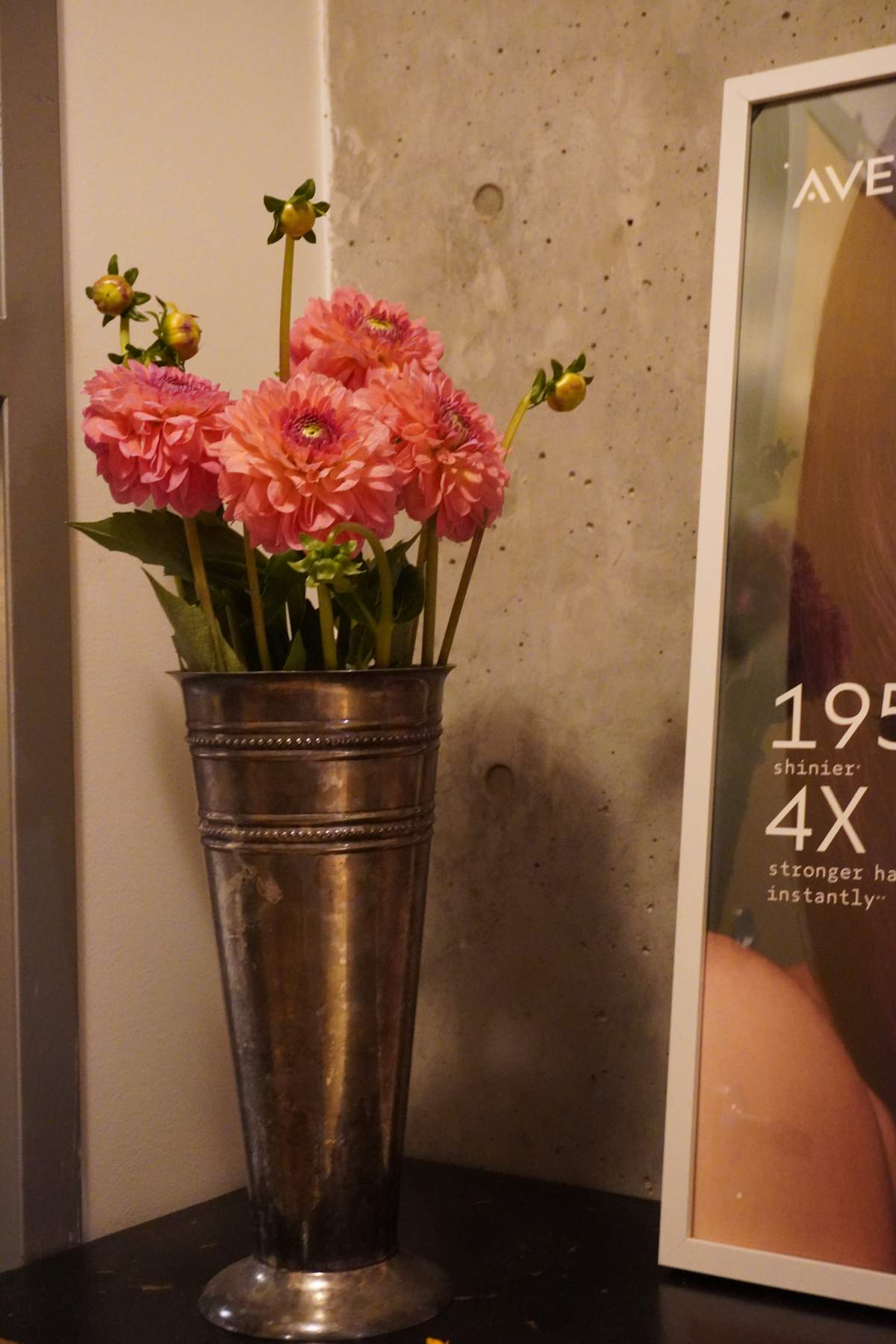 Pink dahlias in a metal vase on a salon counter