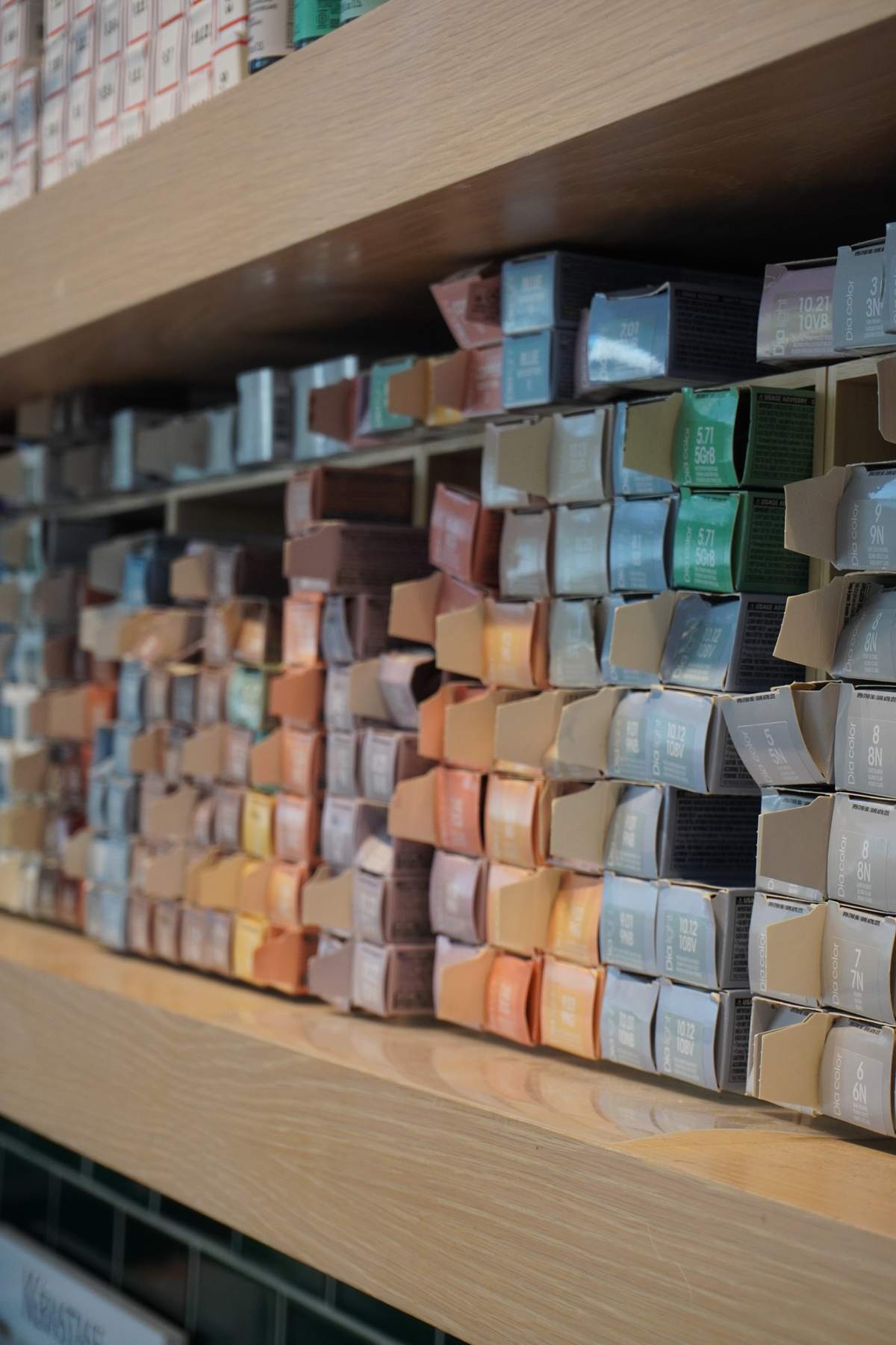 Shelves stacked with boxes of hair colour in a salon colour bar